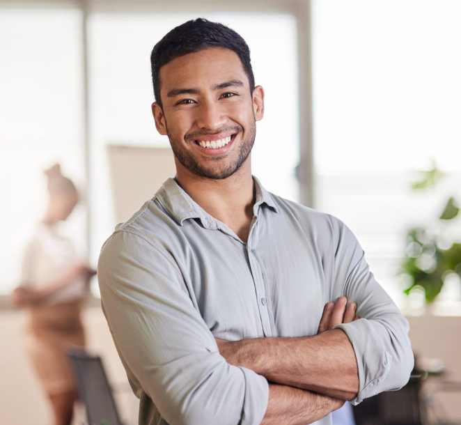 Smiling man with arms crossed in modern dental office setting.